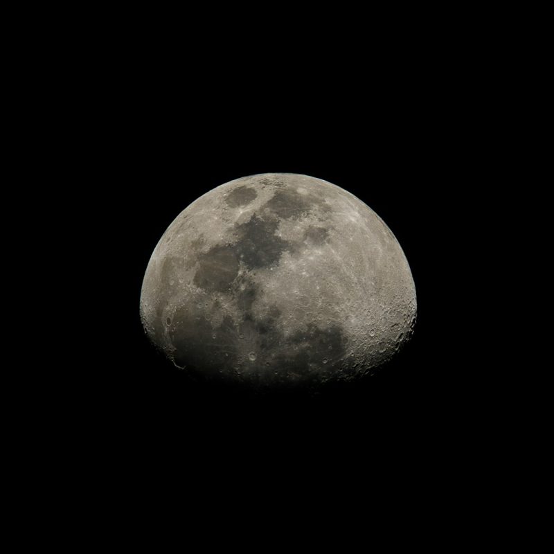 a full moon is seen in the dark sky